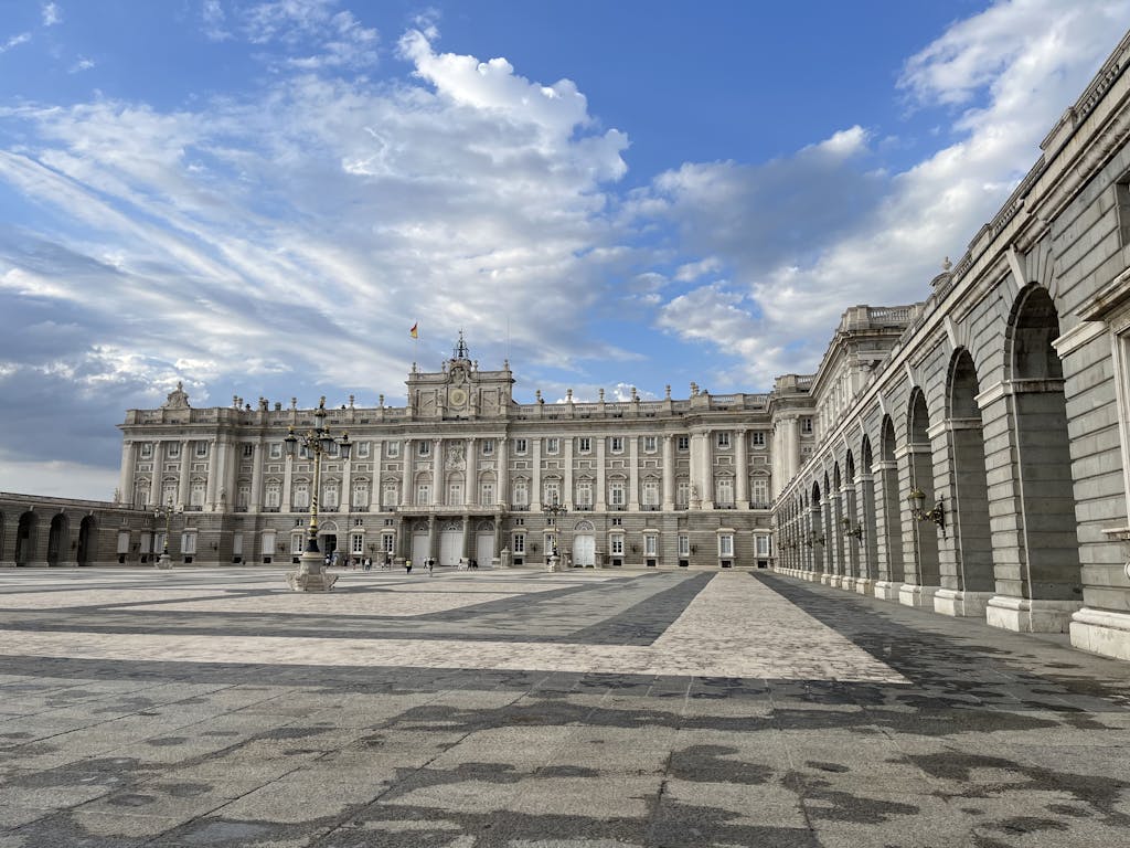 A majestic view of the Royal Palace of Madrid under a vivid blue sky.